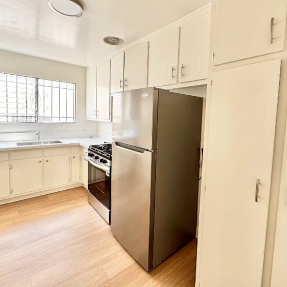 a kitchen with a refrigerator, oven, and cabinets.