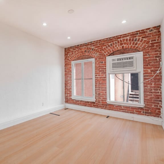 a room with a brick wall and wooden flooring.