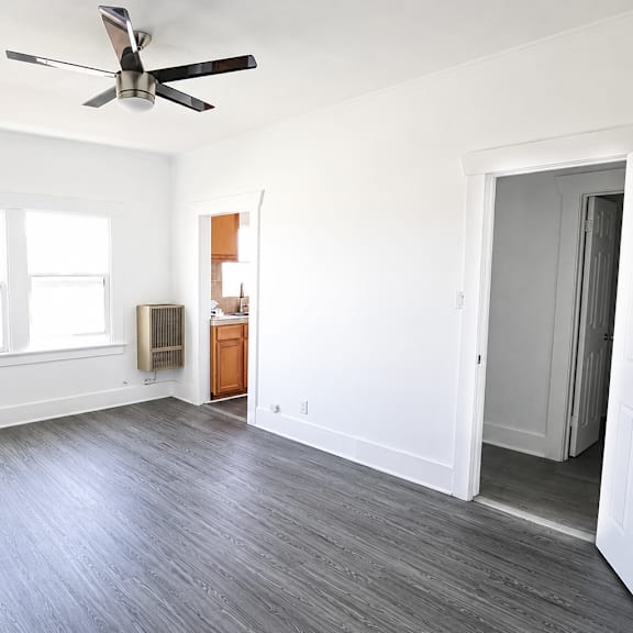 a room with a ceiling fan and a door.