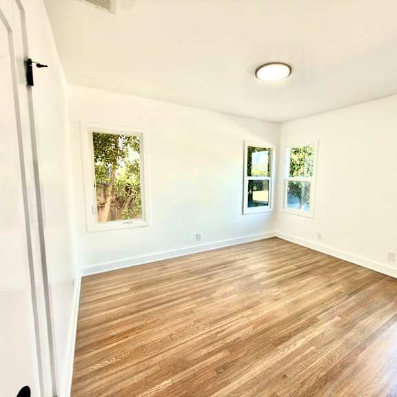 a room with wooden flooring and white walls.