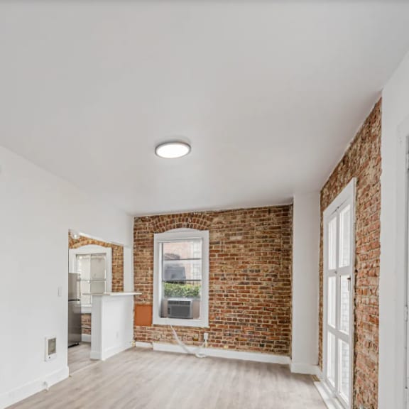 a room with a white door and a brick wall.