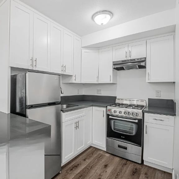 a kitchen with white cabinets and stainless steel appliances.