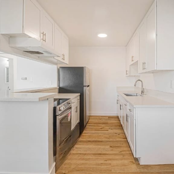 a modern kitchen with white cabinets and appliances.