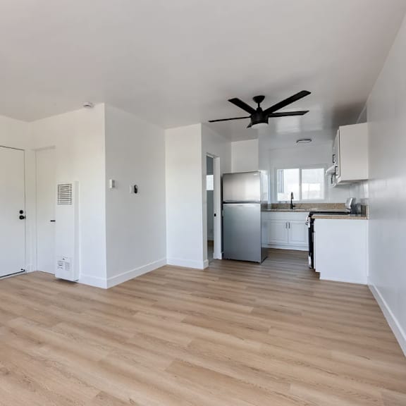 a room with a ceiling fan and wooden flooring.