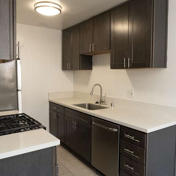 a kitchen with dark brown cabinets and white countertops.
