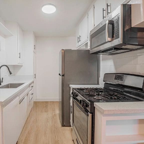 a kitchen with white cabinets and a stainless steel refrigerator.