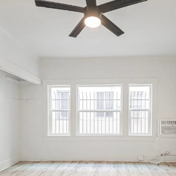 a room with a ceiling fan and a window.