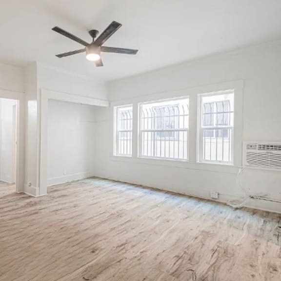 a room with a ceiling fan and hardwood floors.