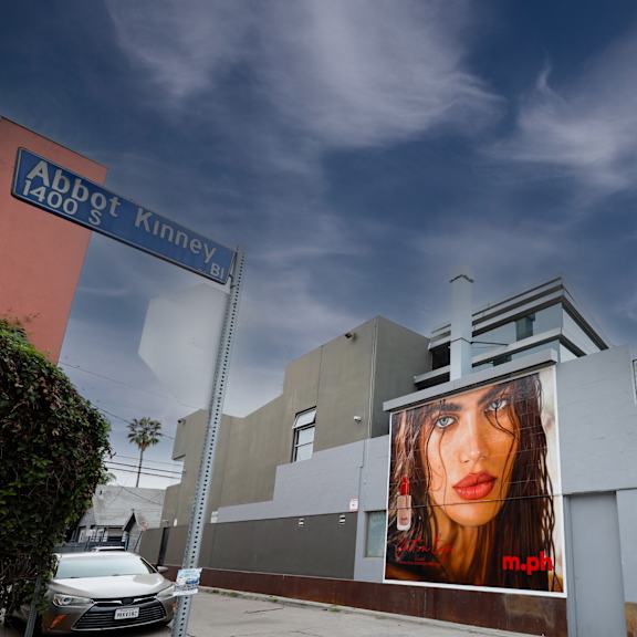 a large billboard with a woman's face on it is on the side of a building.