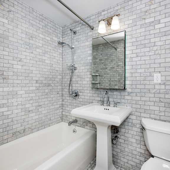 a white sink and toilet in a tiled bathroom.