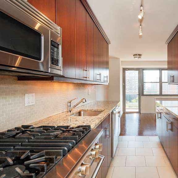 a modern kitchen with dark wood cabinets and stainless steel appliances.
