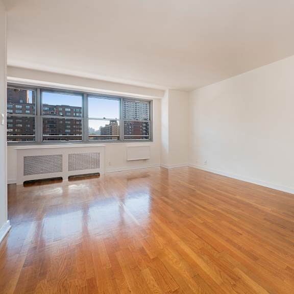 a large empty room with wooden floors and white walls.