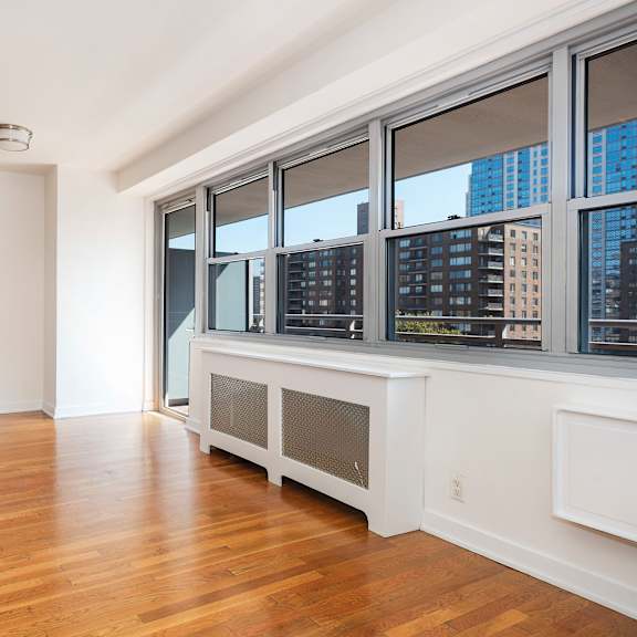 a large empty room with wooden floors and white walls.