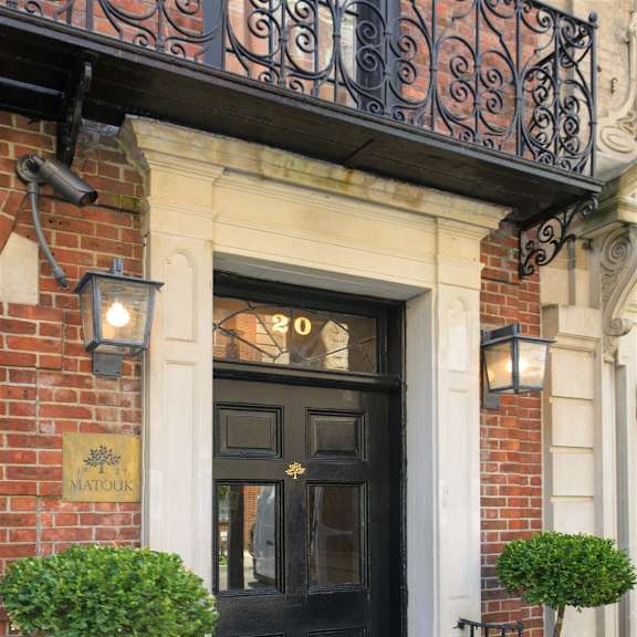 a black door with a gold sign above it that says "matroom".