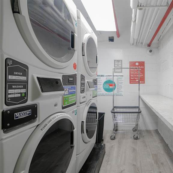 a laundromat with a washing machine and a sign on the wall.