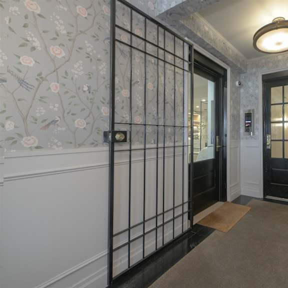 a hallway with a black door and a light on the ceiling.