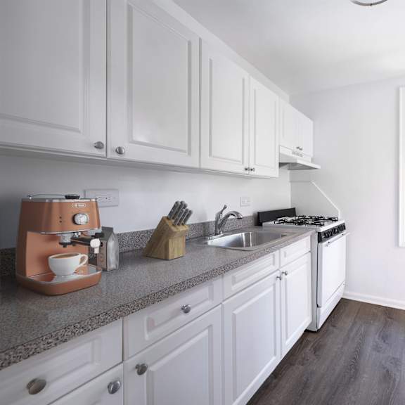 a kitchen with white cabinets and a grey countertop.