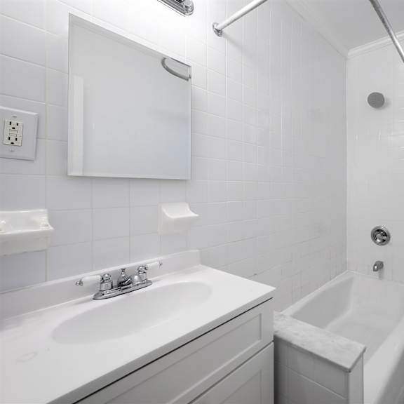a white bathroom with a sink, toilet, and bathtub.