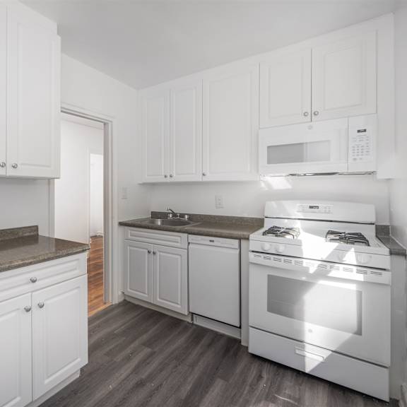 a kitchen with white cabinets and appliances.