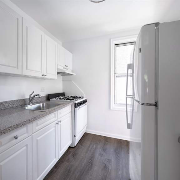 a kitchen with white cabinets and a granite countertop.