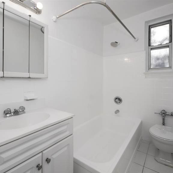 a white bathroom with a sink, toilet, and bathtub.