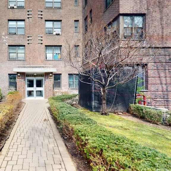 a brick building with a pathway leading to the entrance.