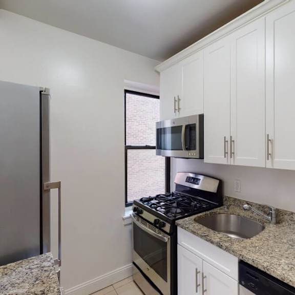 a kitchen with granite countertops and white cabinets.