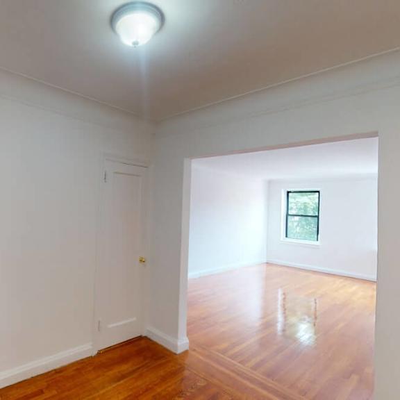 a room with a wooden floor and a window.