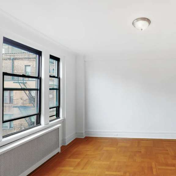 a room with a wooden floor and a window overlooking a city.