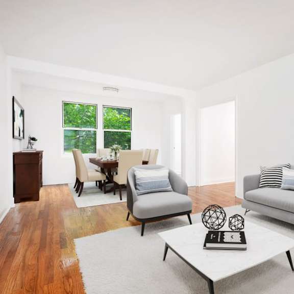 a living room with a grey couch, a white coffee table, and a wooden floor.
