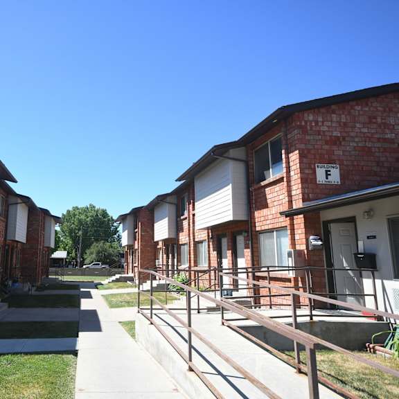 an exterior view of a row of brick apartment buildings on a sidewalk