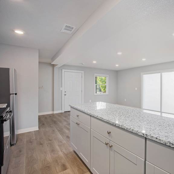 a kitchen with granite countertops and white cabinets.at palisades apartments, kansas city, 64133