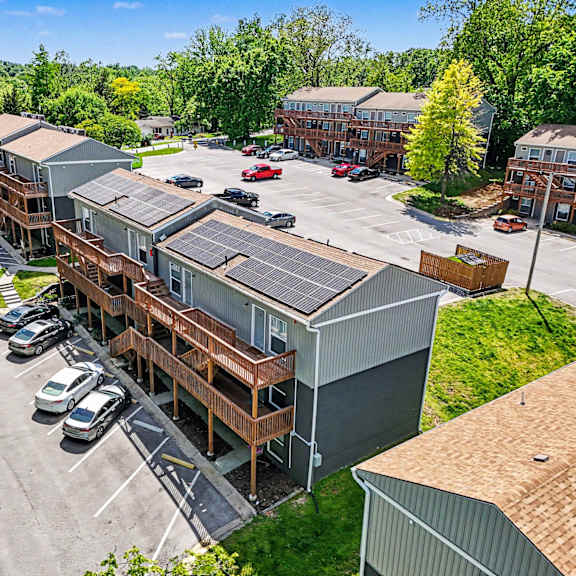 a parking lot with cars and a building with solar panels.