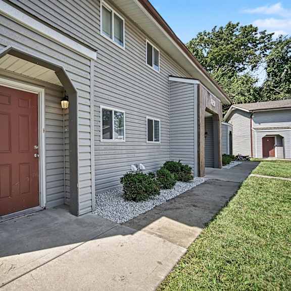 a house with a red door and a grey siding.