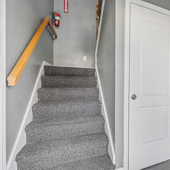 a hallway with a staircase and a door.
