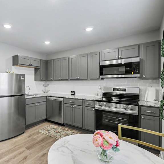 a kitchen with a refrigerator, oven, and microwave at mayfair apartments, missouri, 64145