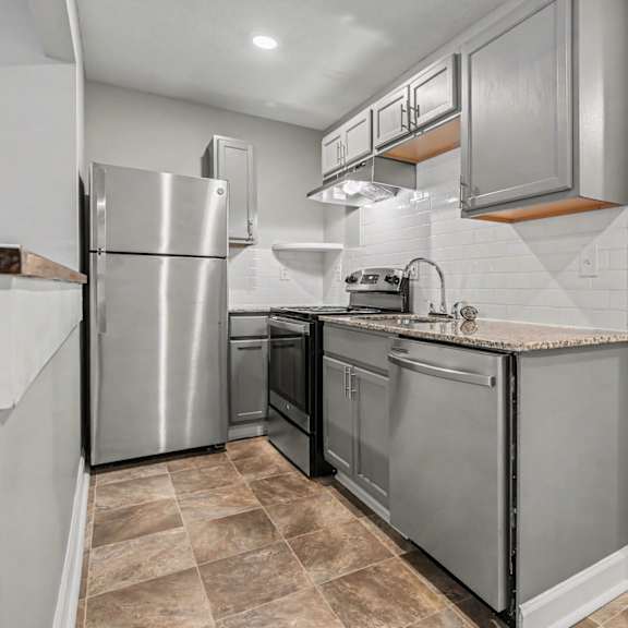 a kitchen with a stainless steel refrigerator and oven.