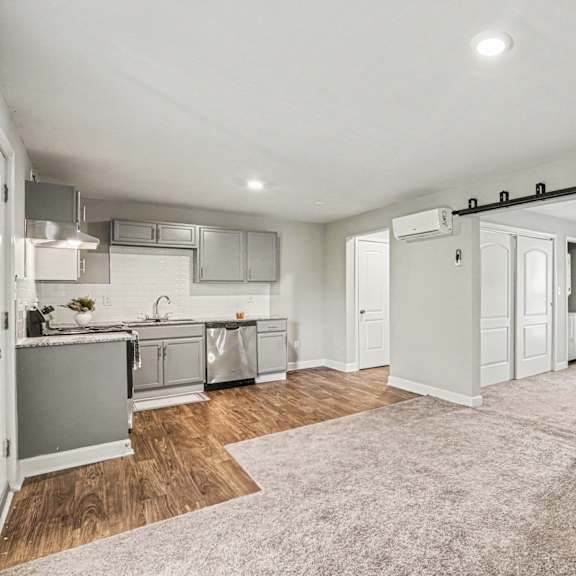 a kitchen with white cabinets and a grey fridge.