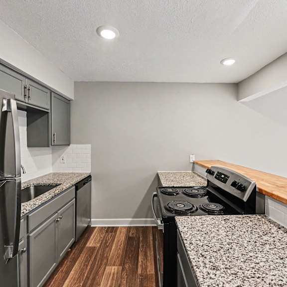 a kitchen with a stainless steel refrigerator and a stove top oven.