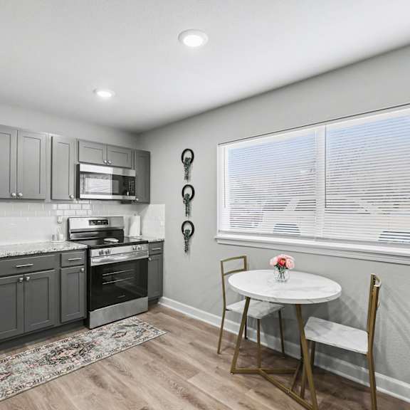 a kitchen with a table and chairs by the window at mayfair apartments, apartments, kansas city, mo