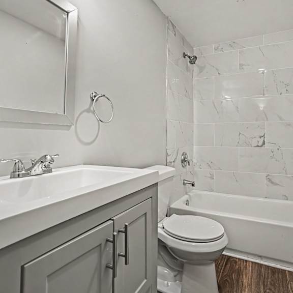 a white bathroom with a marble wall and a white sink.