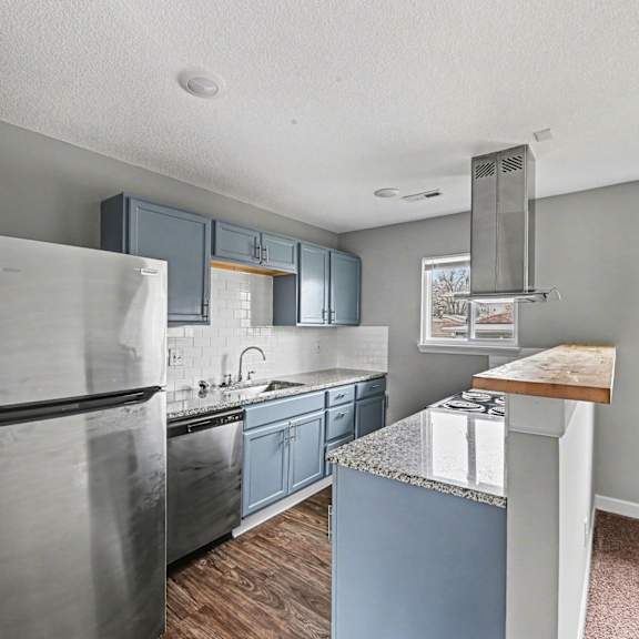a kitchen with a stainless steel refrigerator and blue cabinets.