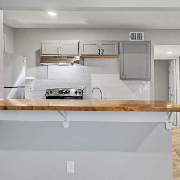 a kitchen with a white refrigerator and a wooden counter top.