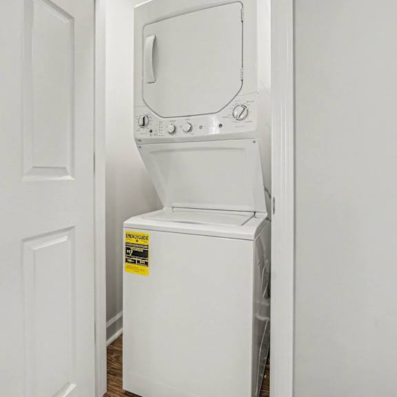 a white washing machine with a yellow sticker on it.