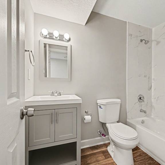 a white toilet sits next to a white sink in a small bathroom.