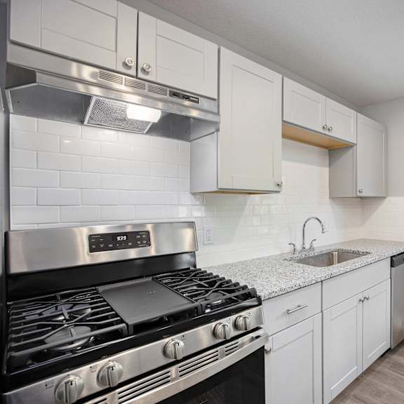 a kitchen with a stove top oven and white cabinets.at palisades apartments, missouri, 64133