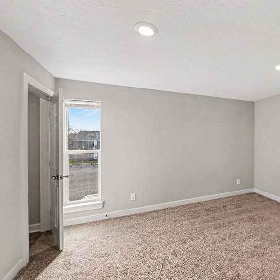 a room with a carpeted floor and a window.