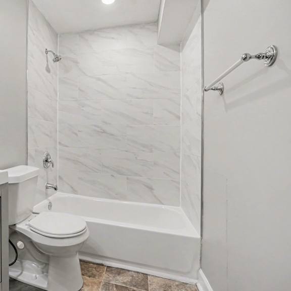 a white bathroom with a toilet, sink, and bathtub.
