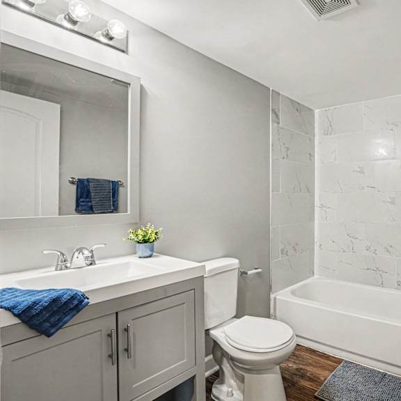 a white bathroom with a toilet, sink, and bathtub.