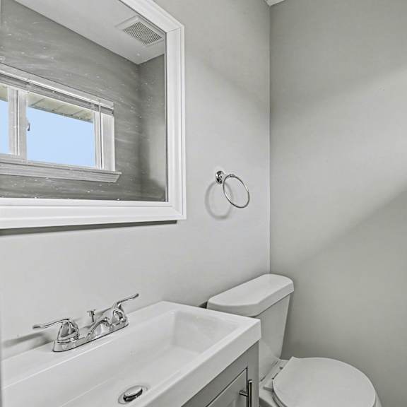 a bathroom with a toilet, sink, and shower.